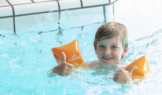 Jongetje in water met duimpjes omhoog.jpg